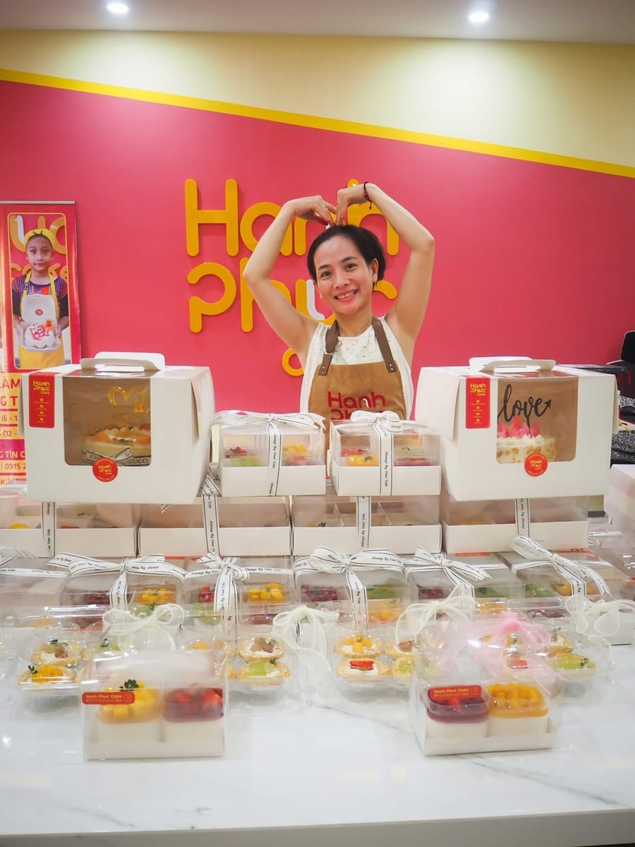 Trinh tạo dáng tim cùng bàn bánh Hanh Phuc Cake